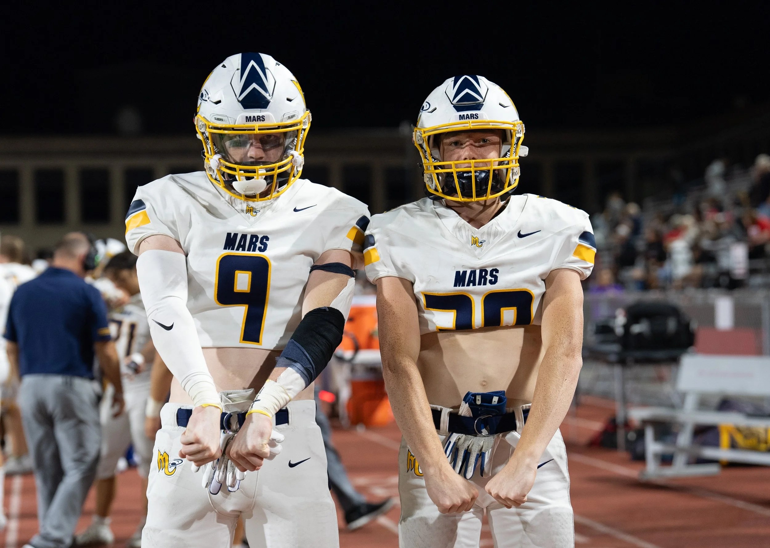 High school football players in white jerseys